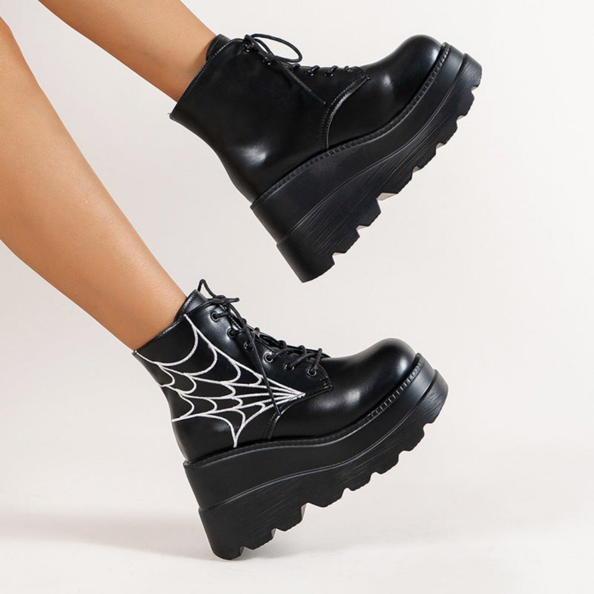Bottes femme noires à lacets avec semelle compensée et motif toile d’araignée vue de profil